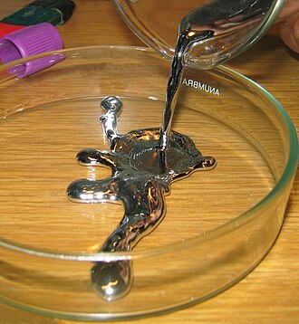 流動する液体の水銀。光沢と丸くまとまる表面が見えます。